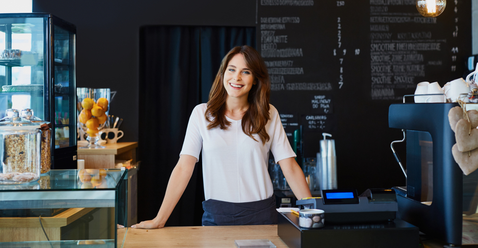 A woman standing behind the counter at a cafe