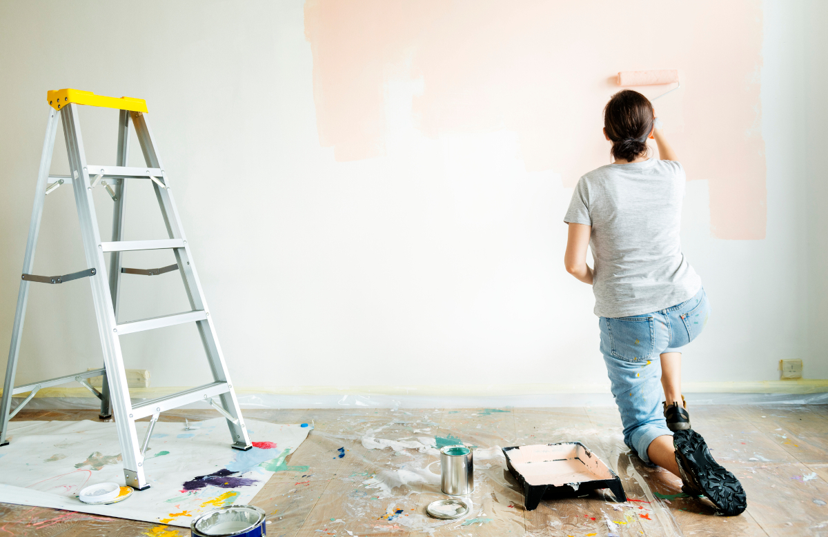 Women painting a wall to improve her business